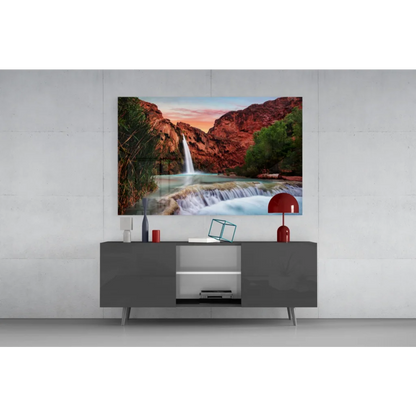 Vibrant glass wall art of waterfall cascading over red canyon cliffs
