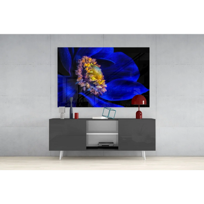 Vibrant blue and yellow glass wall art on black canvas atop gray console