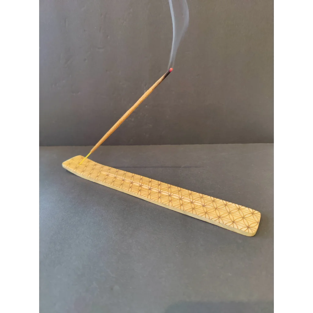 Light wood incense burner with geometric star pattern and burning stick