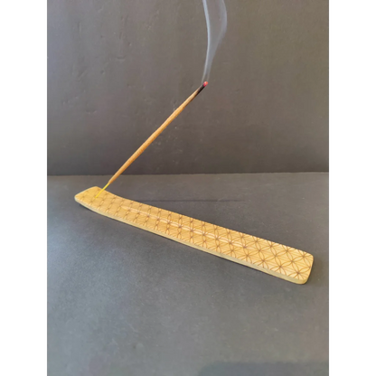 Light wood incense burner with geometric star pattern and burning stick