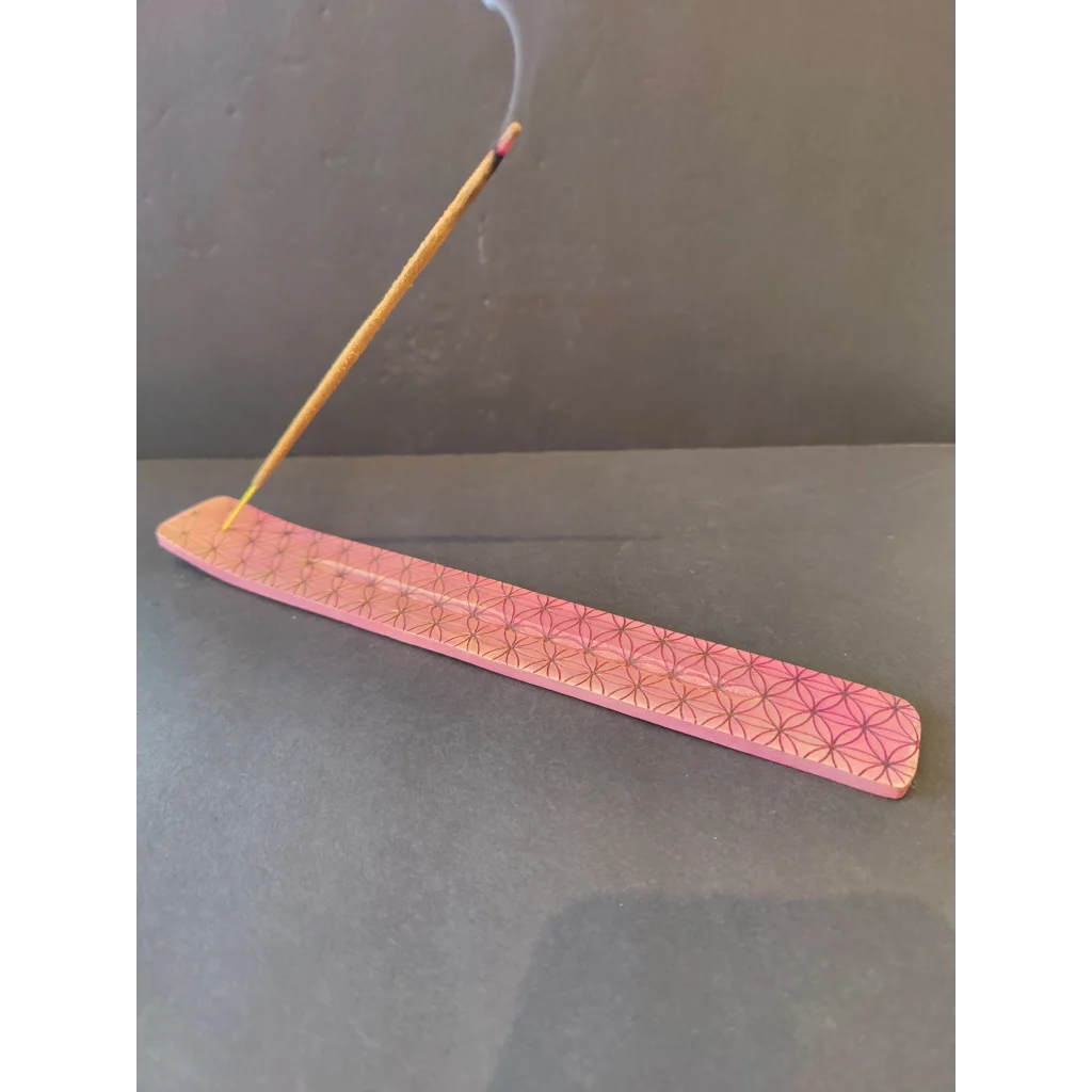 Pink geometric wooden incense burner holding burning stick