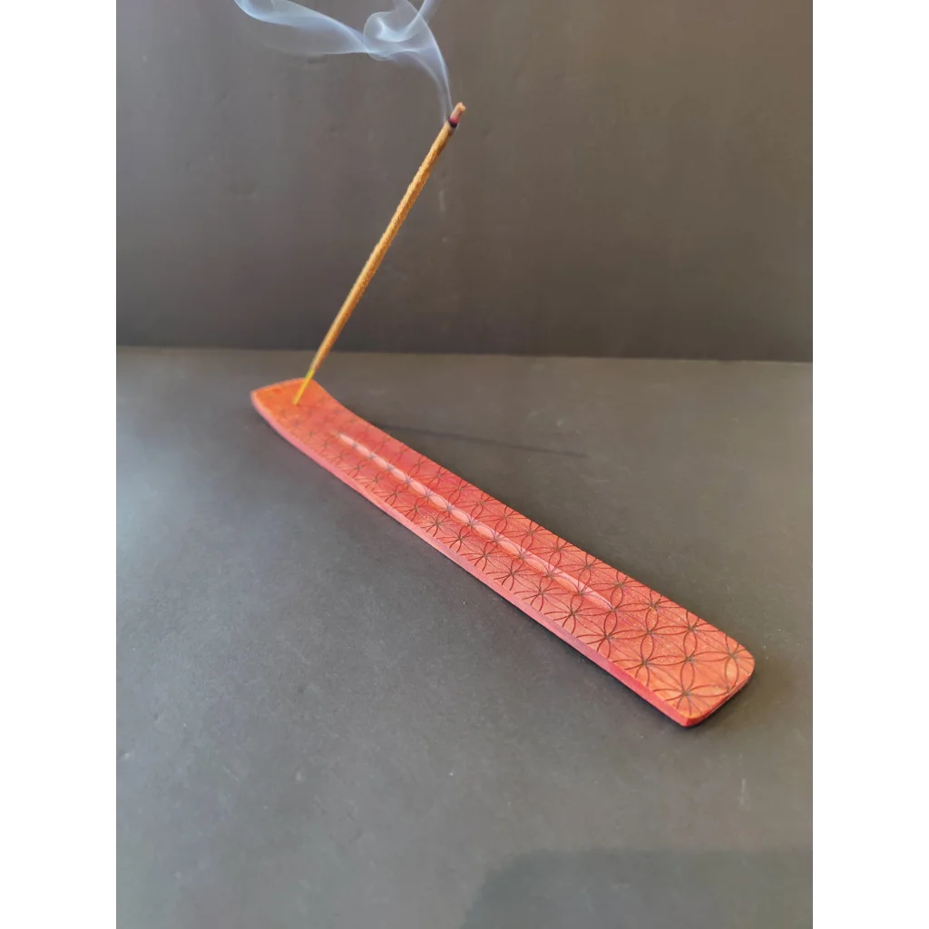 Reddish-orange wood printed incense burner with lit stick and smoke