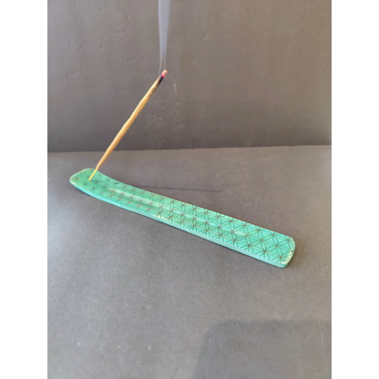 Teal ceramic incense burner with wood print holding burning stick