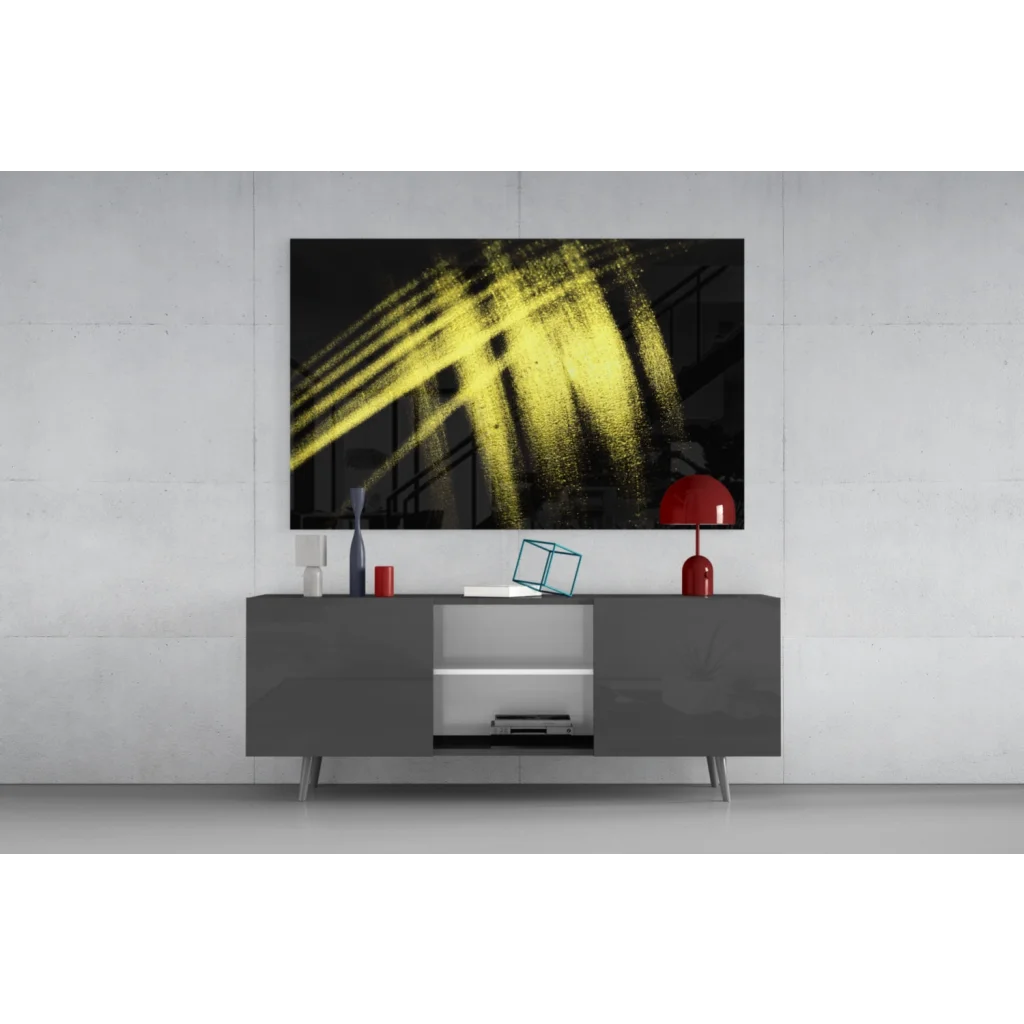 Bold yellow brushstroke glass wall art on black canvas above gray console