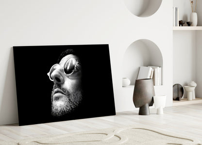 Black and white portrait glass art of bearded man wearing sunglasses displayed in minimalist white interior space.