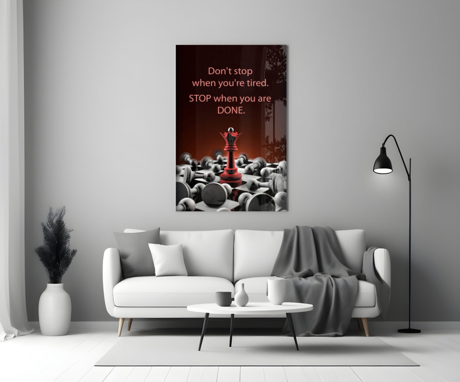 Motivational glass wall art with red chess piece and scattered gray pieces, mounted above white sofa in minimalist living room.