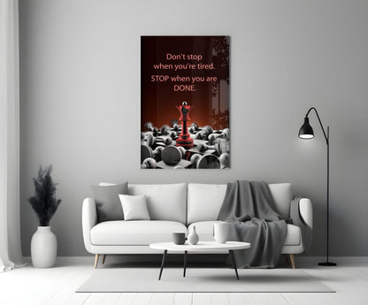 Motivational glass wall art with red chess piece and scattered gray pieces, mounted above white sofa in minimalist living room.