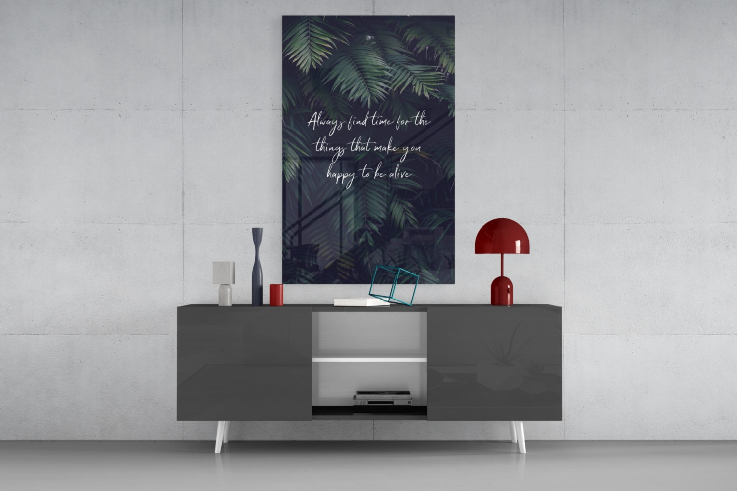 Dark glass wall art with fern leaves and white script text "Always find time for the things that make you happy to be alive" displayed above a grey media console.