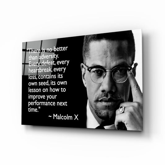 Black and white glass wall art featuring a man in glasses with a Malcolm X quote about adversity and improvement printed in white text.