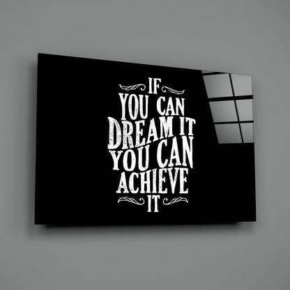 Black glass wall art panel displaying white motivational text "If You Can Dream It You Can Achieve It" with decorative flourishes, angled view showing depth.