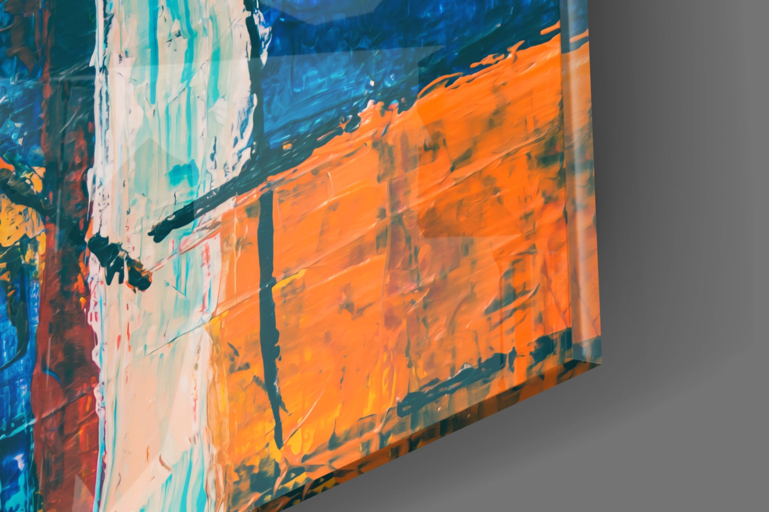 Close-up angled view of glass wall art displaying vibrant orange, blue, teal, and white abstract brushstrokes with layered translucent glass texture.