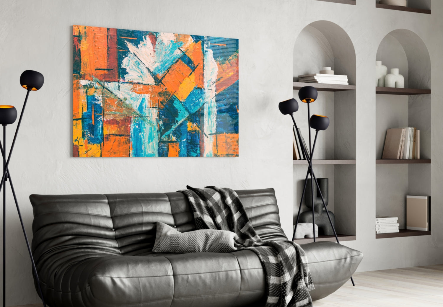 Orange Dream Glass Wall Art displayed above a black leather sofa in a modern living room with white built-in shelving.