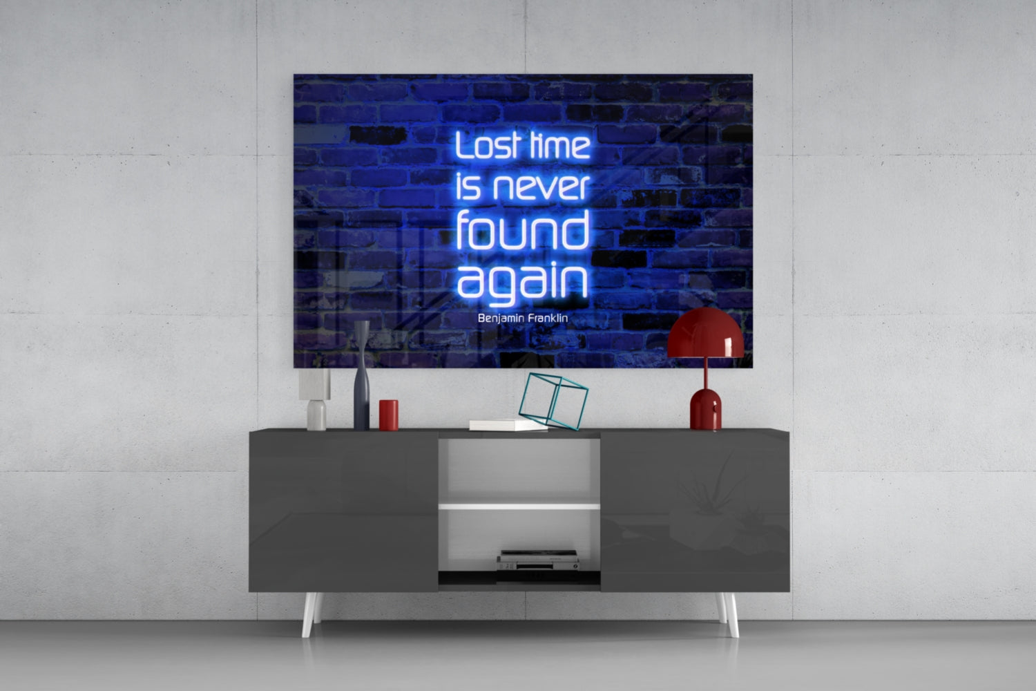 Blue neon Benjamin Franklin quote mounted on brick wall above modern gray media console with red lamp and decorative objects.