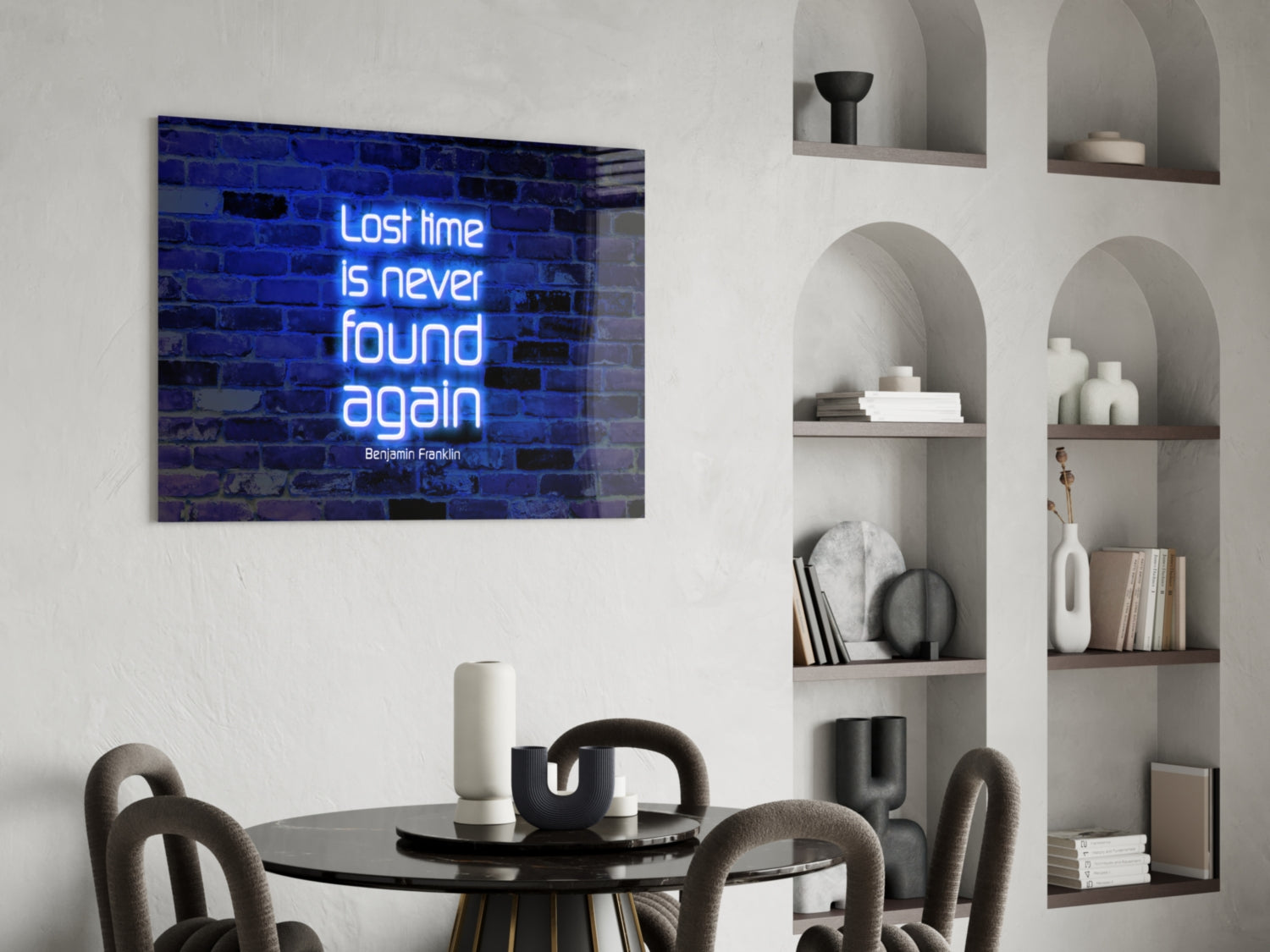 Blue neon glass wall art with Benjamin Franklin quote displayed above round black dining table with gray chairs.