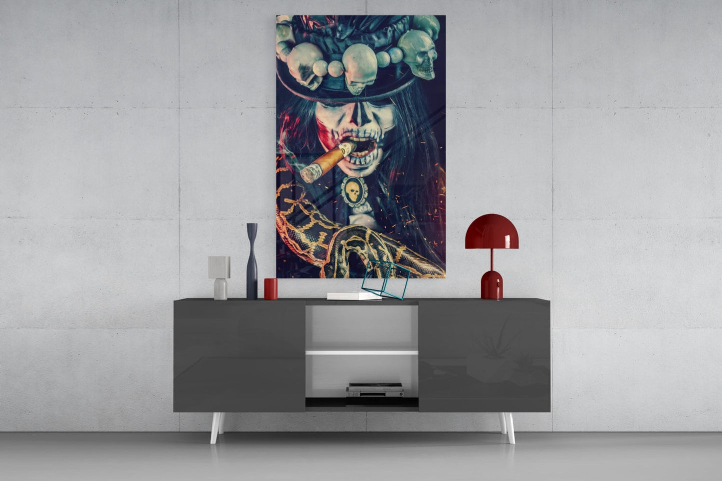 Skeleton portrait glass wall art with skull, red fabric, and gold accents displayed above a dark gray console table.