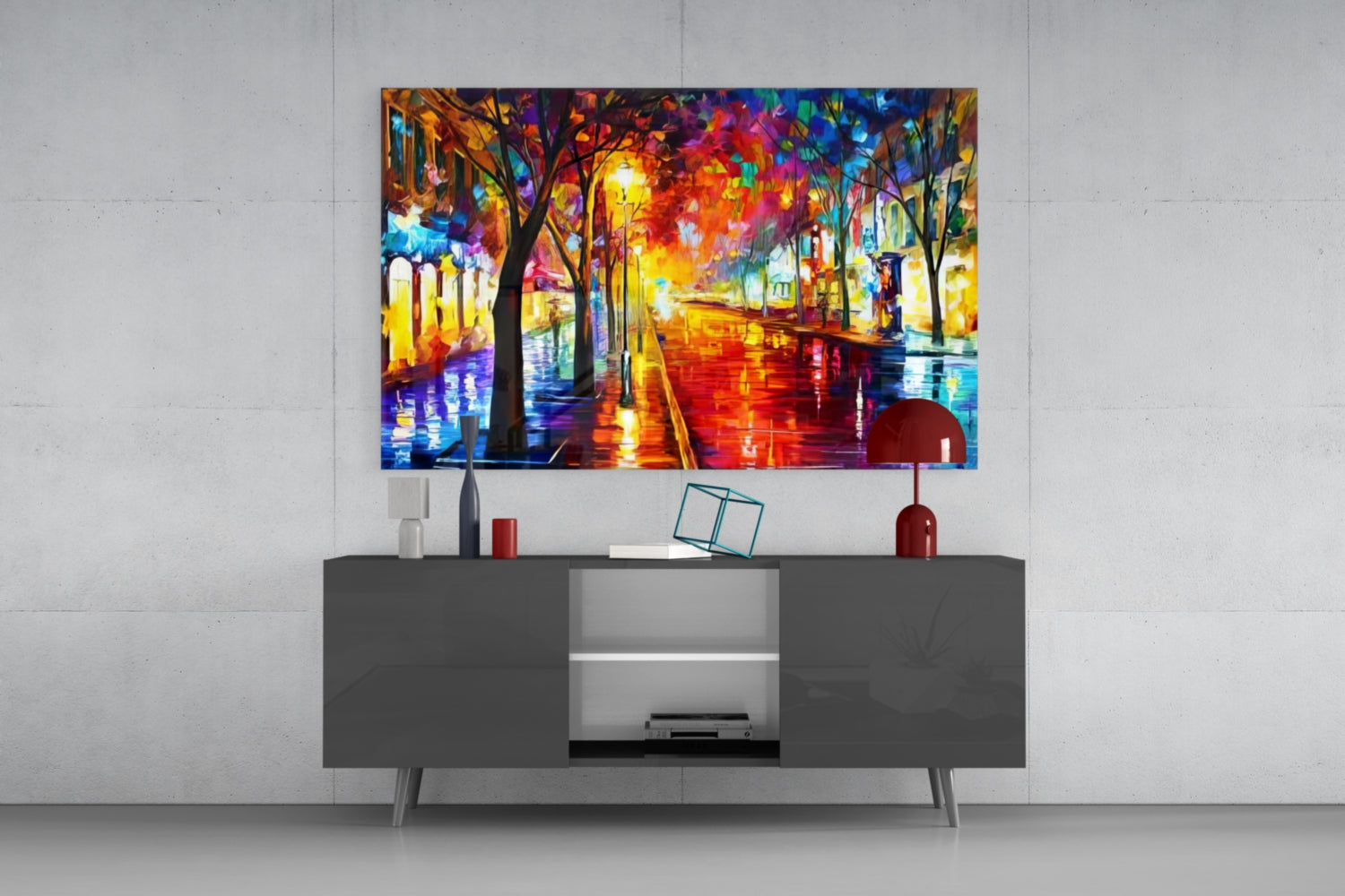 Colorful illuminated street scene glass art displayed above gray media console with decorative accessories.