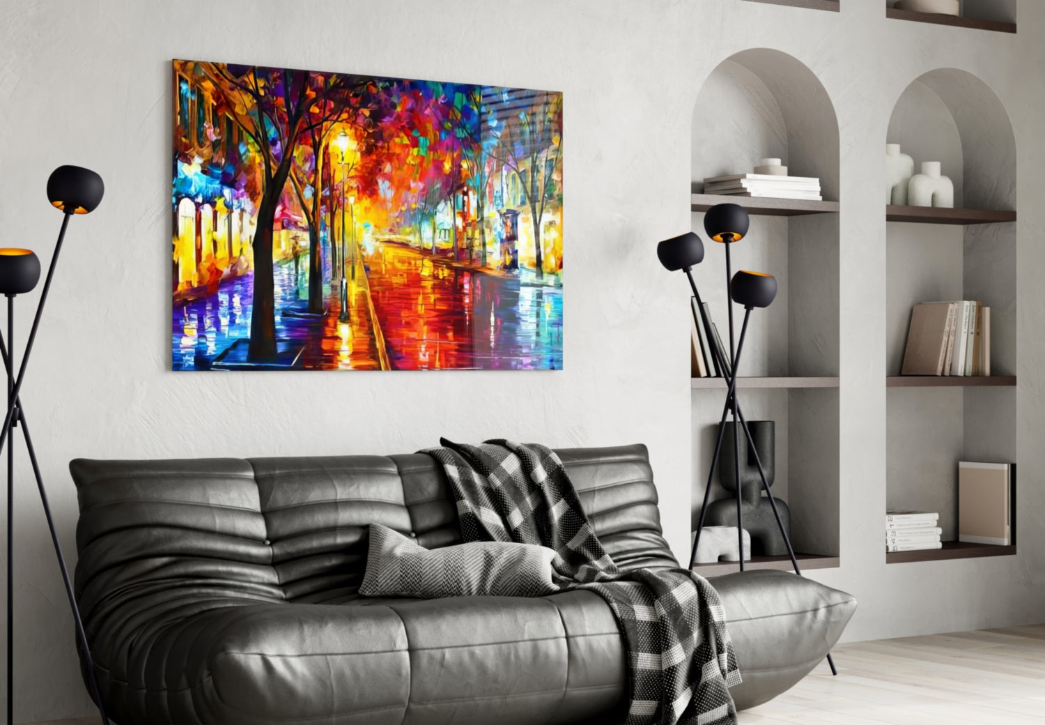 Vibrant glass wall art depicting a colorful rainy street with glowing trees and lights, displayed above a black leather sofa in a modern living room.