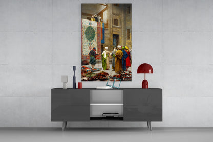 Glass wall art depicting a carpet seller in a Middle Eastern interior displayed above a gray media console with decorative accessories.