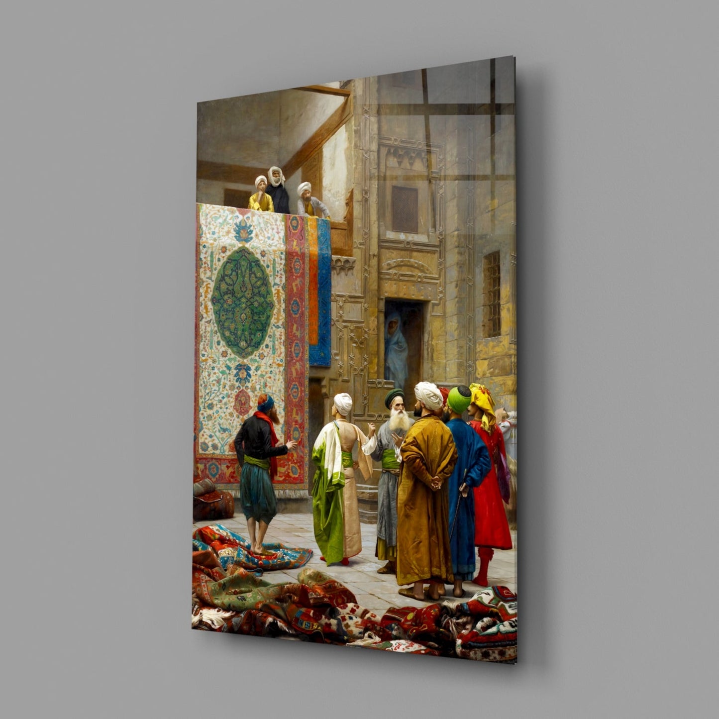 Glass wall art depicting a Middle Eastern carpet bazaar scene with figures in colorful robes examining ornate textiles displayed indoors.