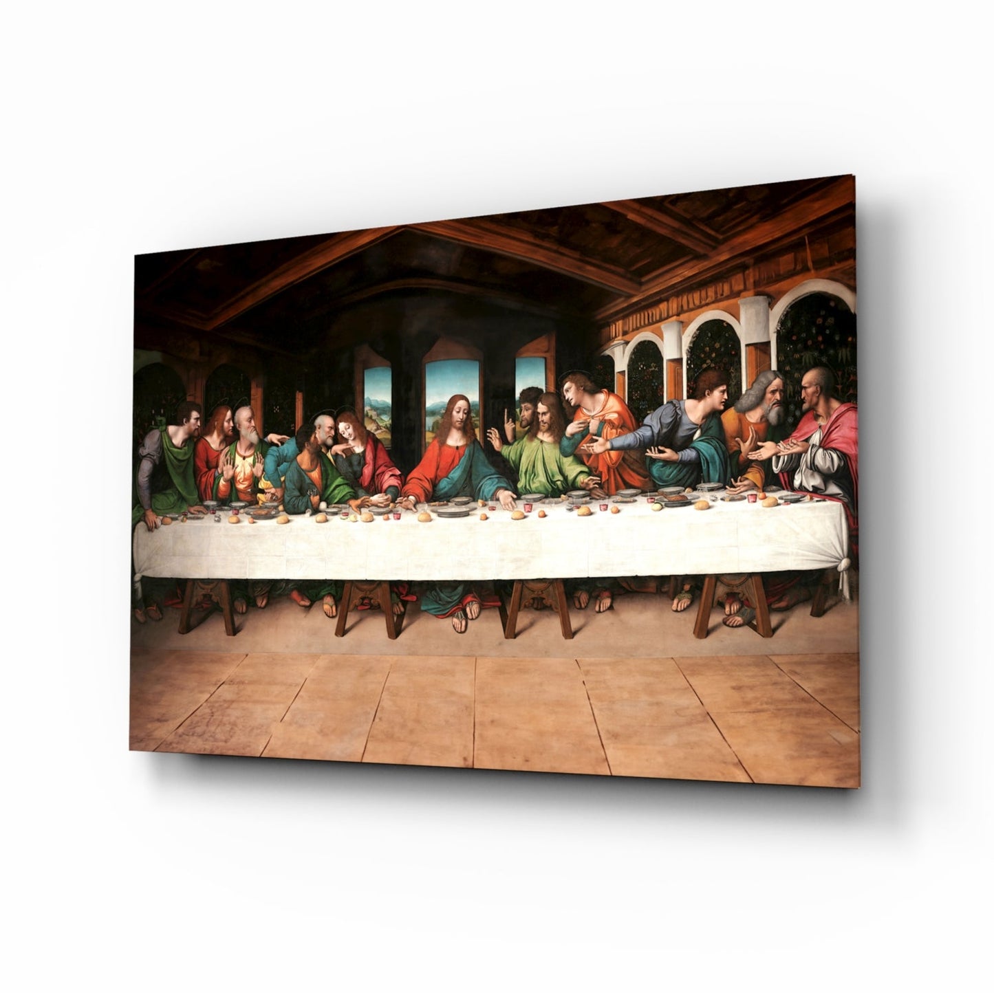 Glass wall art depicting the Last Supper displayed at an angled perspective, showing wooden interior with figures in colorful robes seated at a long table.