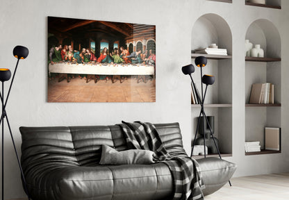 Modern living room interior featuring black leather sofa with Last Supper glass wall art above it, styled with black floor lamp and white shelving unit.