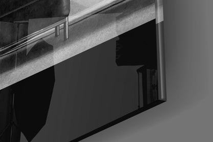 Black and white architectural photograph showing a modernist concrete building facade with horizontal railings and a dark recessed window opening.