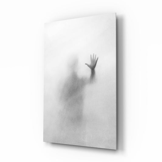 Angled perspective of frosted glass wall art displaying a blurred silhouette with one raised hand against white background.