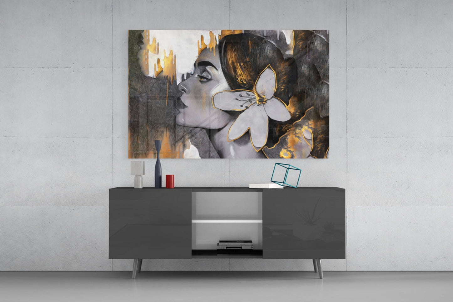 Modern living room setting displaying Gipsy Beauty glass wall art above dark console table, featuring portrait with gold and gray tones.