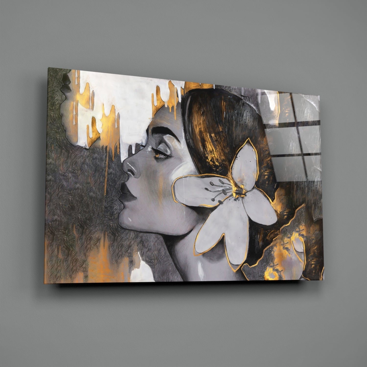 Glass wall art featuring a profile portrait of a woman with gold and black accents, displaying flowing hair and a white flower with gold outline against textured background.