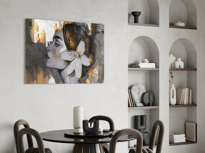 Glass wall art depicting a woman's profile with gold and gray tones and a white flower, displayed in a modern dining room.