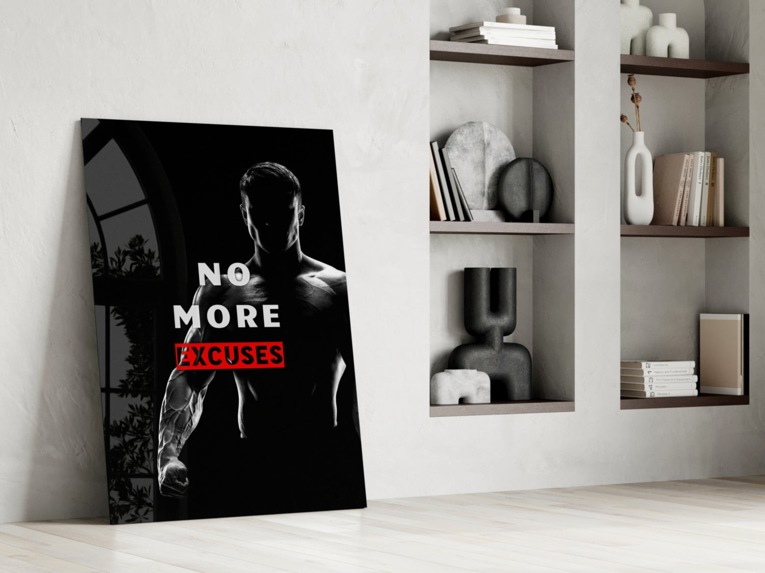 Black glass wall art leaning against white wall displaying muscular man silhouette with "NO MORE EXCUSES" text in white and red, styled room setting with shelving visible.