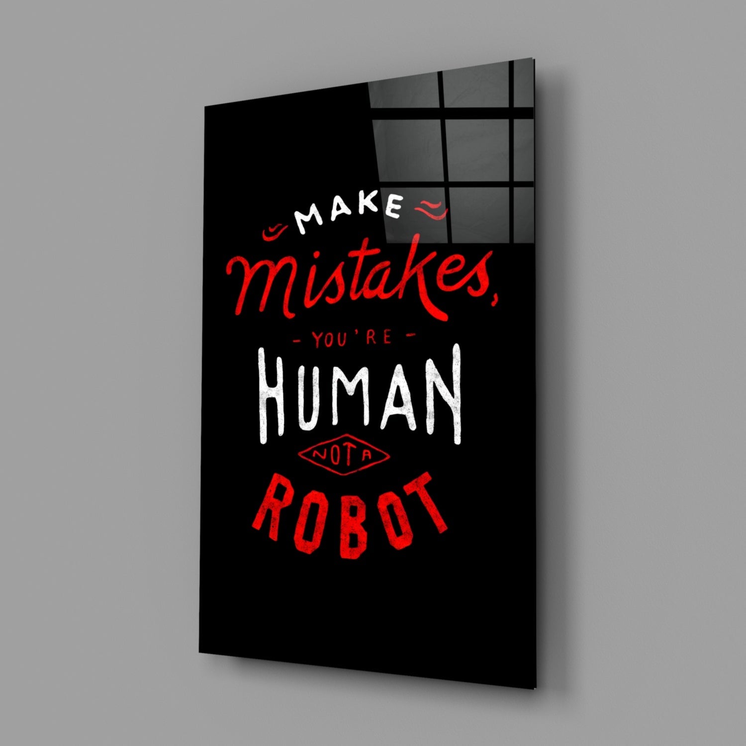 Black glass wall art panel with red and white text reading "Make mistakes, you're human not a robot" displayed at an angle against gray background.