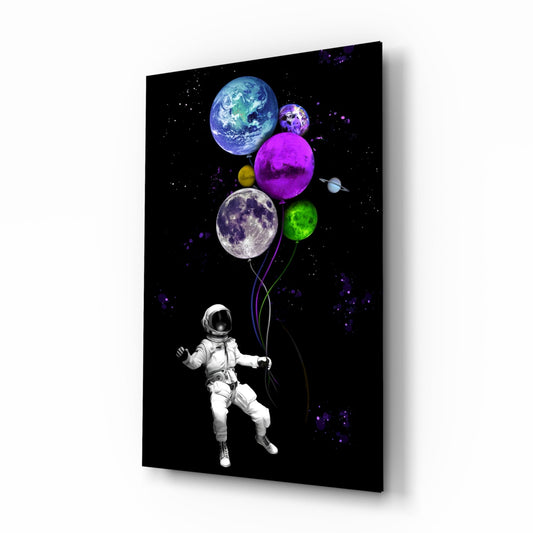 Astronaut in white spacesuit holding colorful planet balloons against black starry space background on glass wall art.