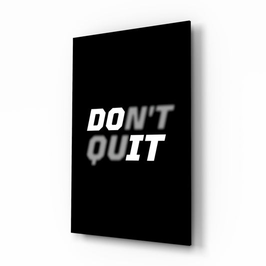 Black glass wall art panel displaying white italic text "DON'T QUIT" shown at an angled perspective view.