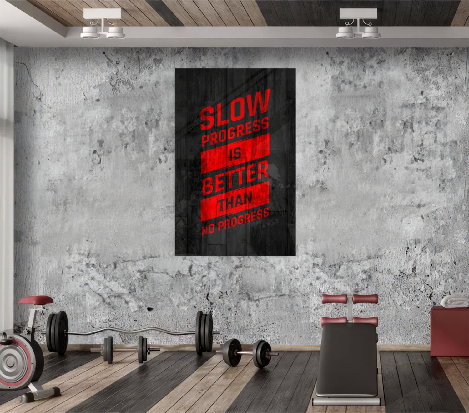 Modern gym interior with concrete wall displaying red and black glass art reading "Slow Progress is Better Than No Progress" above exercise equipment.
