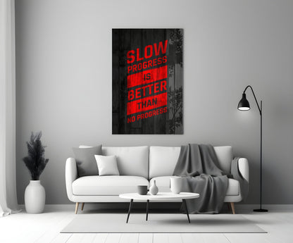Red neon-style text reading "SLOW PROGRESS IS BETTER THAN NO PROGRESS" displayed on black wood-textured glass art hanging above a white sofa in a modern living room.