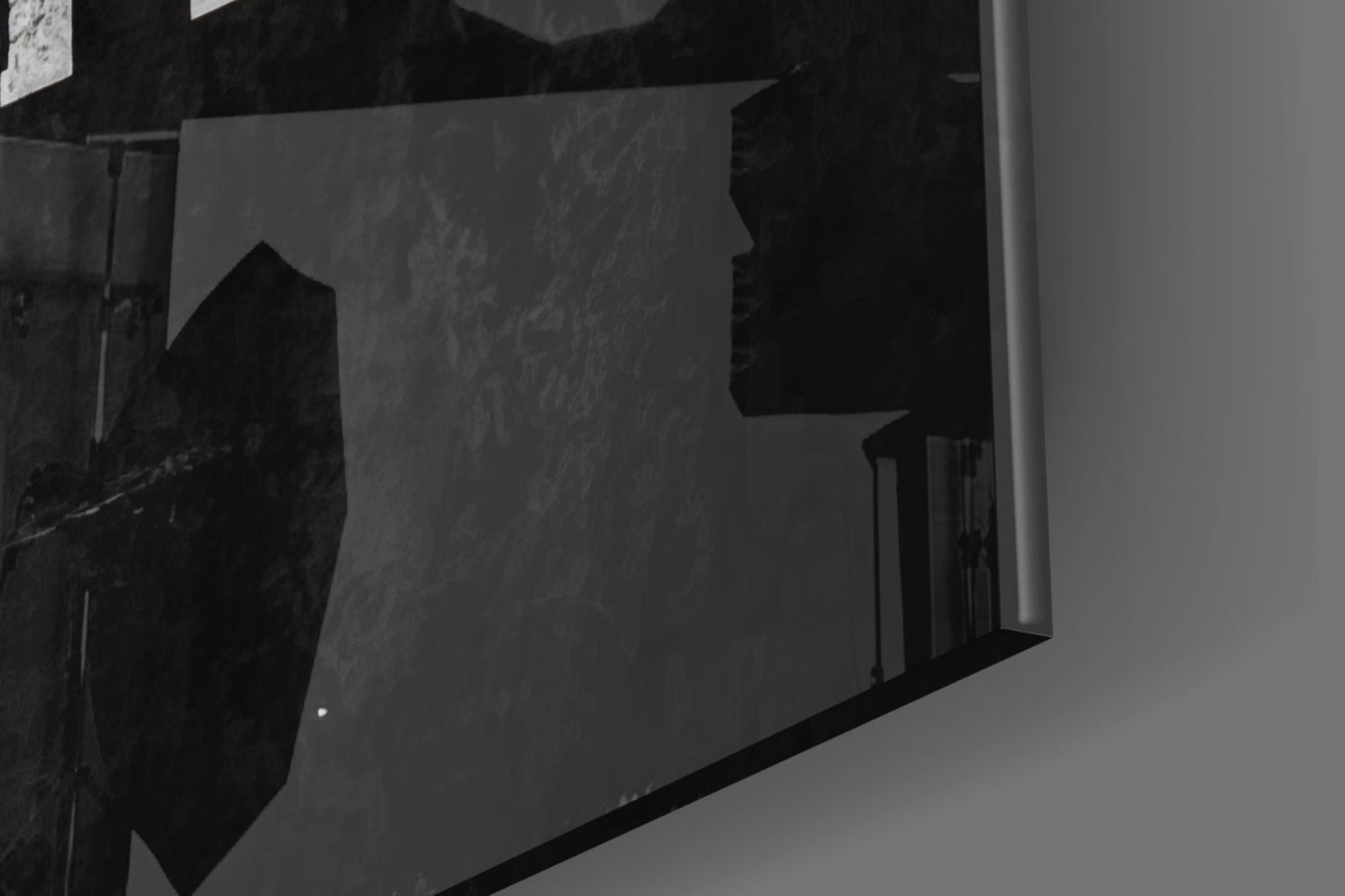 Black and white photo showing glass wall art mounted on interior wall corner, displaying silhouetted text design.