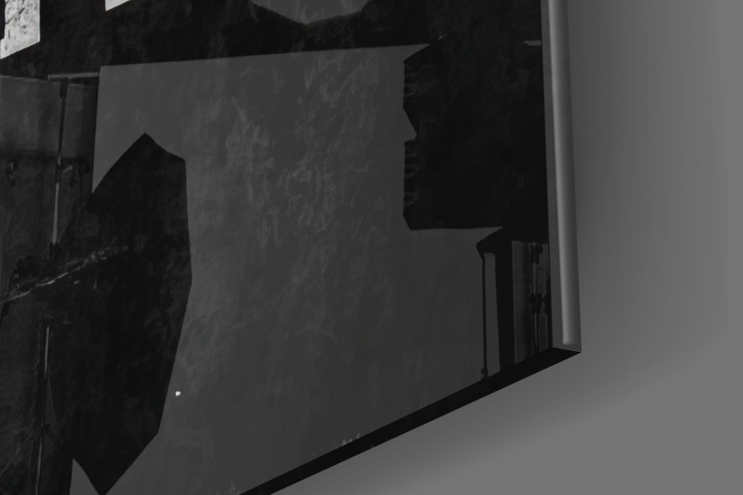 Black and white photo showing glass wall art mounted on interior wall corner, displaying silhouetted text design.