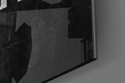 Black and white photo showing glass wall art mounted on interior wall corner, displaying silhouetted text design.