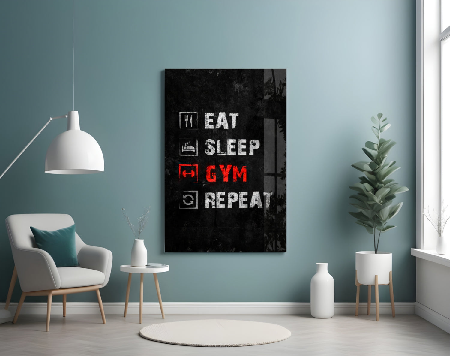 Black glass wall art displaying "Eat Sleep Gym Repeat" in white and red text, mounted in a minimalist room with teal walls and white furniture.