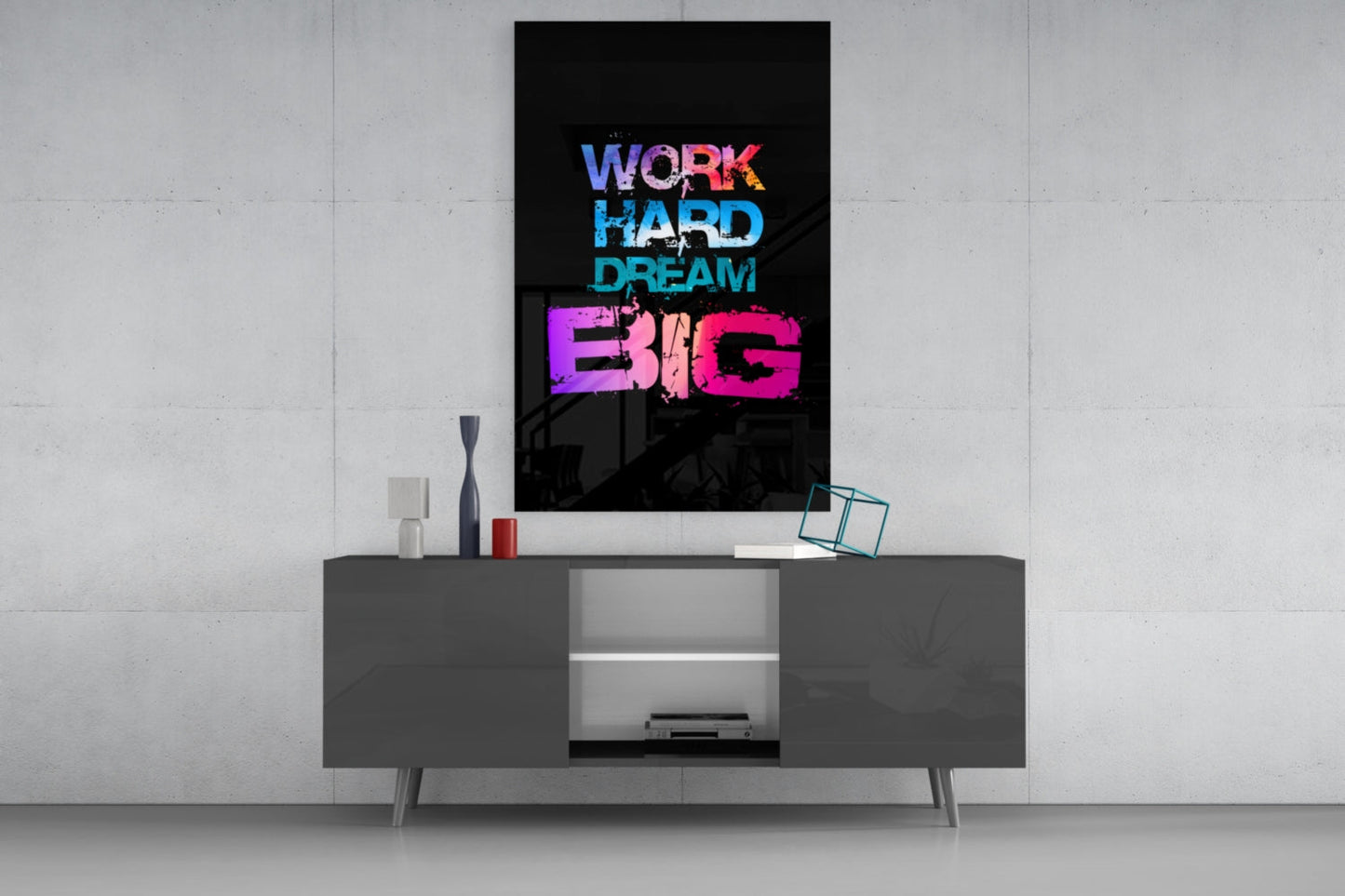 Neon "Work Hard Dream Big" glass wall art in blue, cyan, and pink displayed above a gray media console in a modern interior setting.