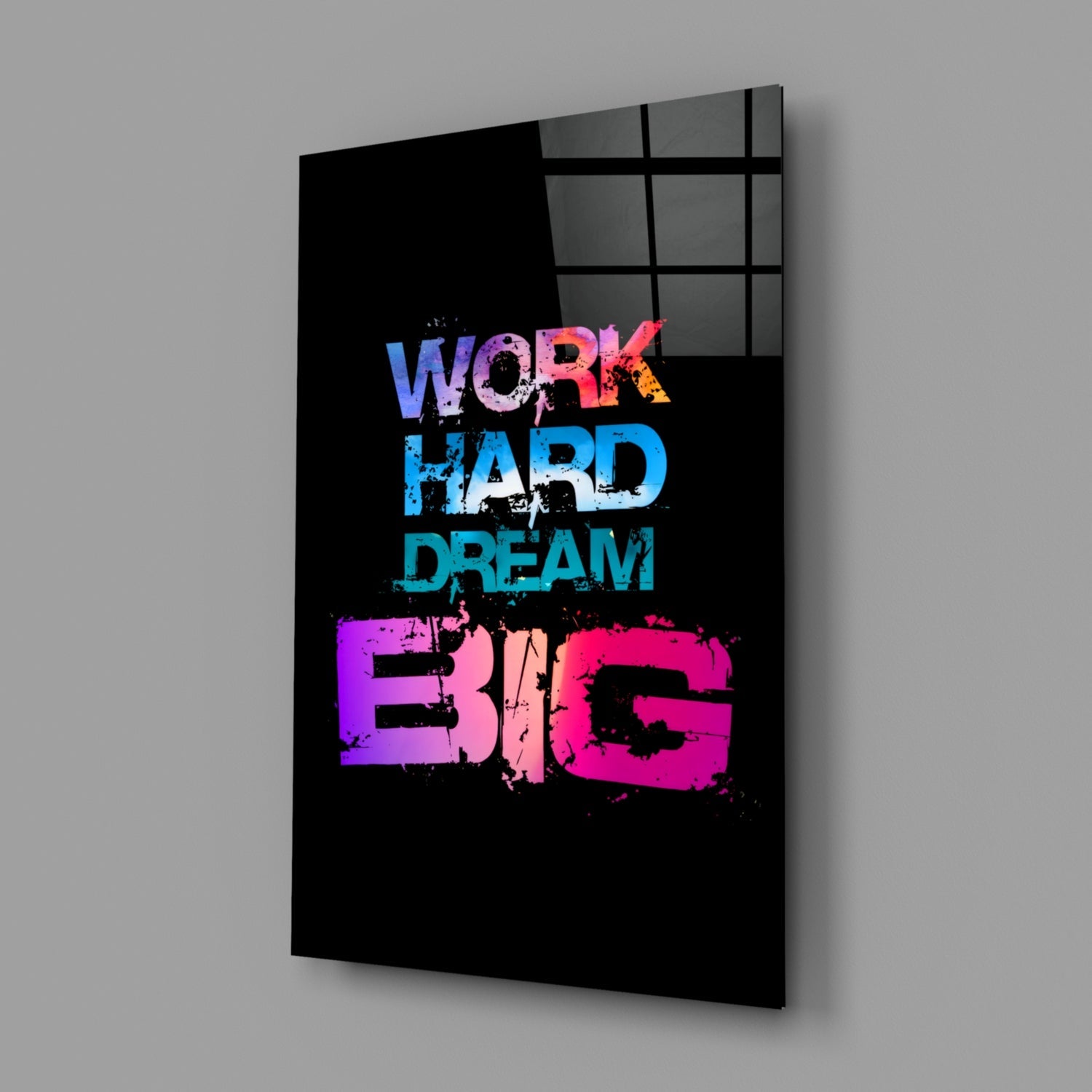 Black glass wall art panel with colorful gradient text reading "WORK HARD DREAM BIG," displayed at an angle against gray background.