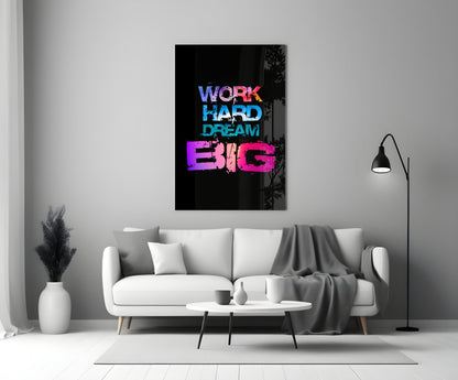 Neon glass wall art with "WORK HARD DREAM BIG" text in blue, cyan, and pink displayed above a white sofa in a modern living room.