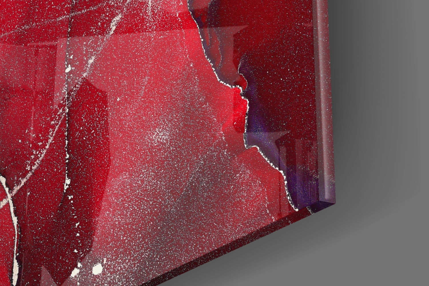 Close-up detail of red marbled glass wall art with white veining and dark purple accents against gray background.