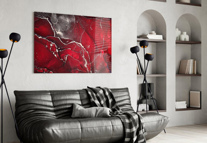 Red Marbellous glass wall art displayed above black leather sofa in modern living room with built-in shelving.