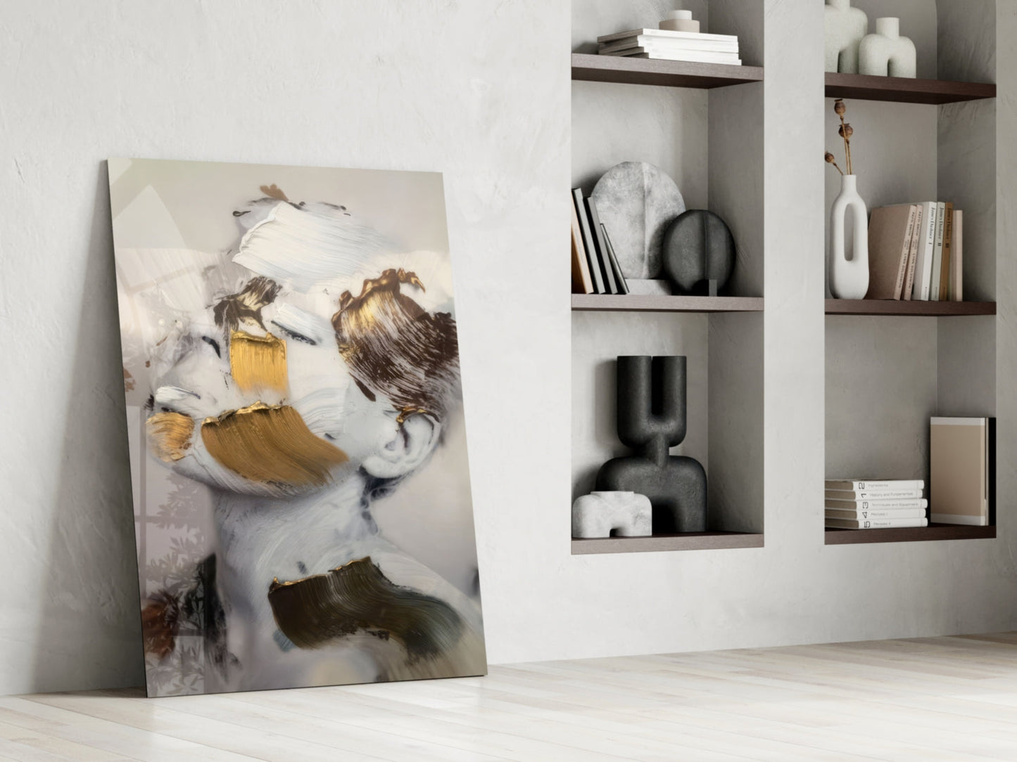 Abstract brushed face glass wall art leaning against white wall beside shelving unit, featuring golden and brown brushstrokes on white background.