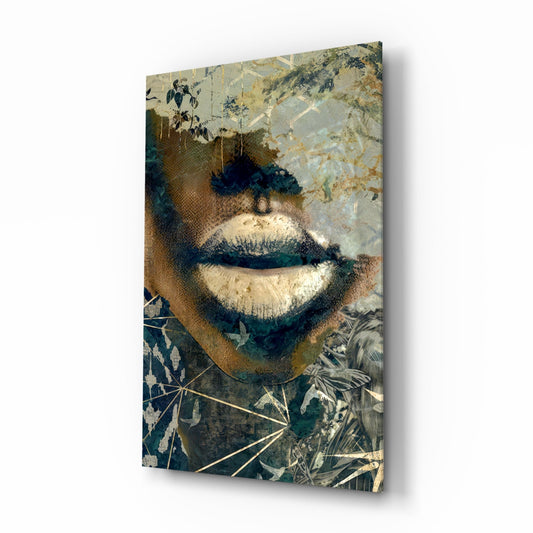 Glass wall art displaying close-up portrait with botanical collage elements in gold, teal, and cream tones, angled perspective view.