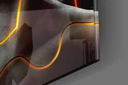 Close-up angled view of Frequency Glass Wall Art showing orange and yellow neon tubing curves against textured gray glass panels.