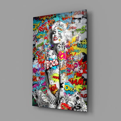 Angled view of glass wall art featuring black and white portrait with colorful comic book graffiti text and speech bubbles overlay.