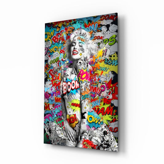 Angled view of glass wall art featuring black-and-white portrait with colorful comic book speech bubbles and pop art graffiti overlay.